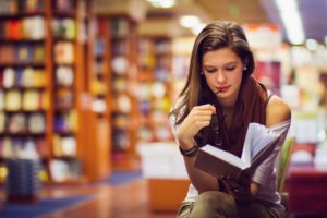 teen reading in a library