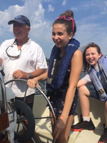 sailing the Shrewsbury River for dyslexia group of 3 people steering a boat